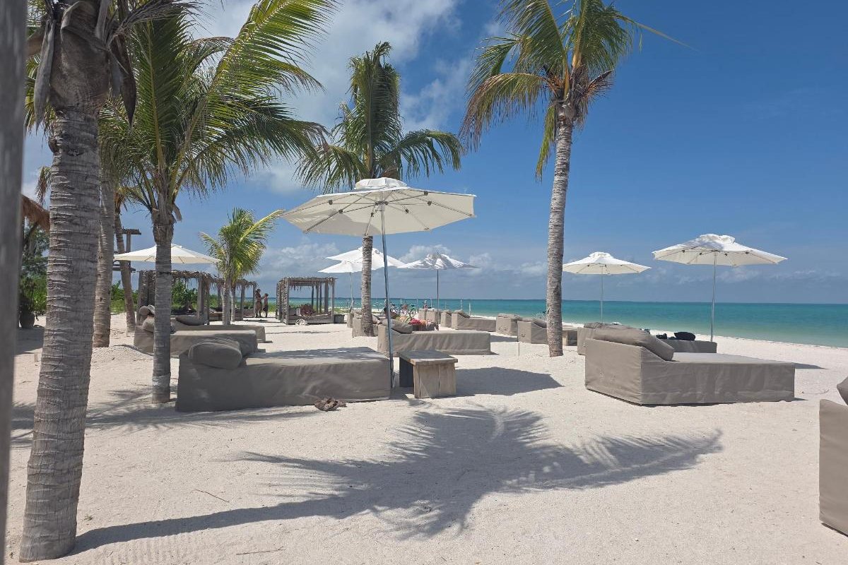 Camastros y sombrillas del beach club Naay frente al mar en Holbox