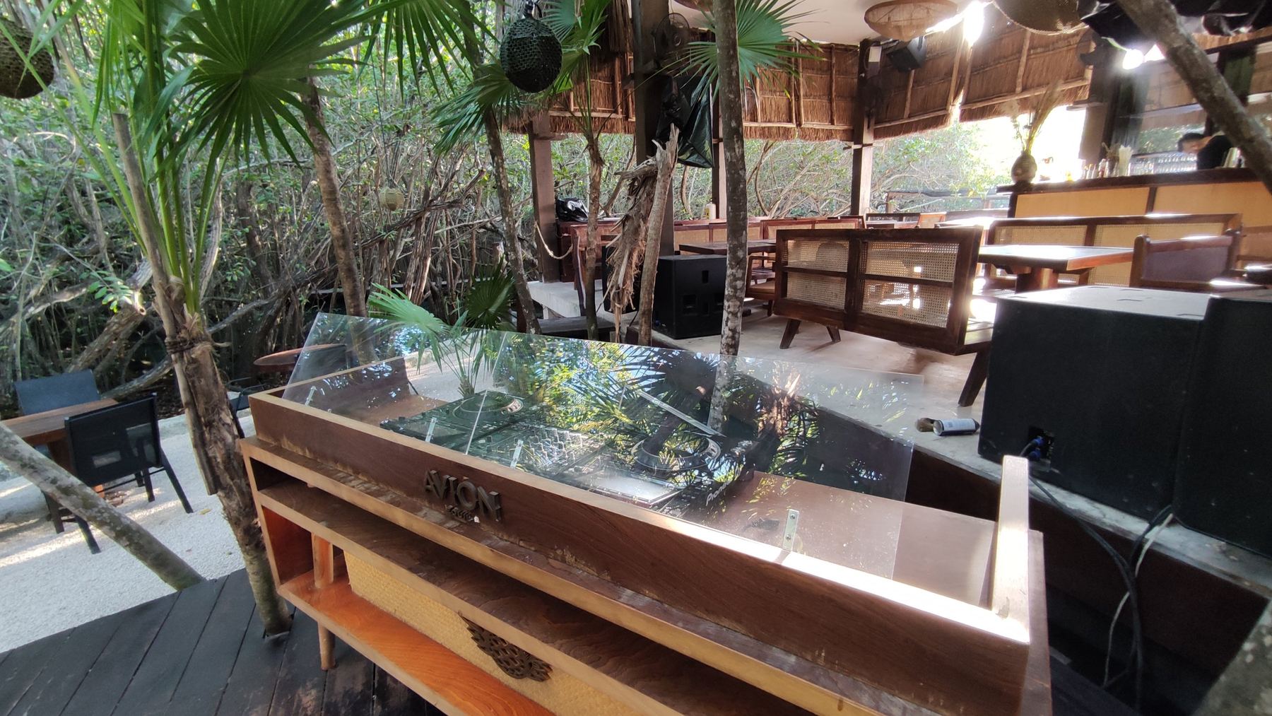 DJ booth and subwoofers in a restaurant open to the jungle