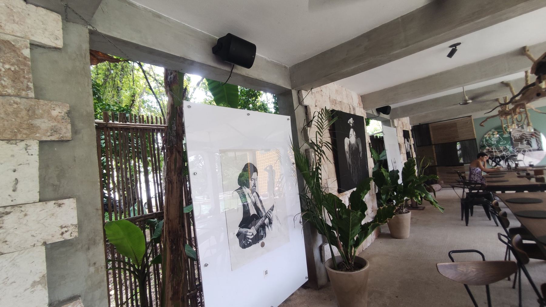Covered terrace with artworks and loudspeakers mounted on the beams