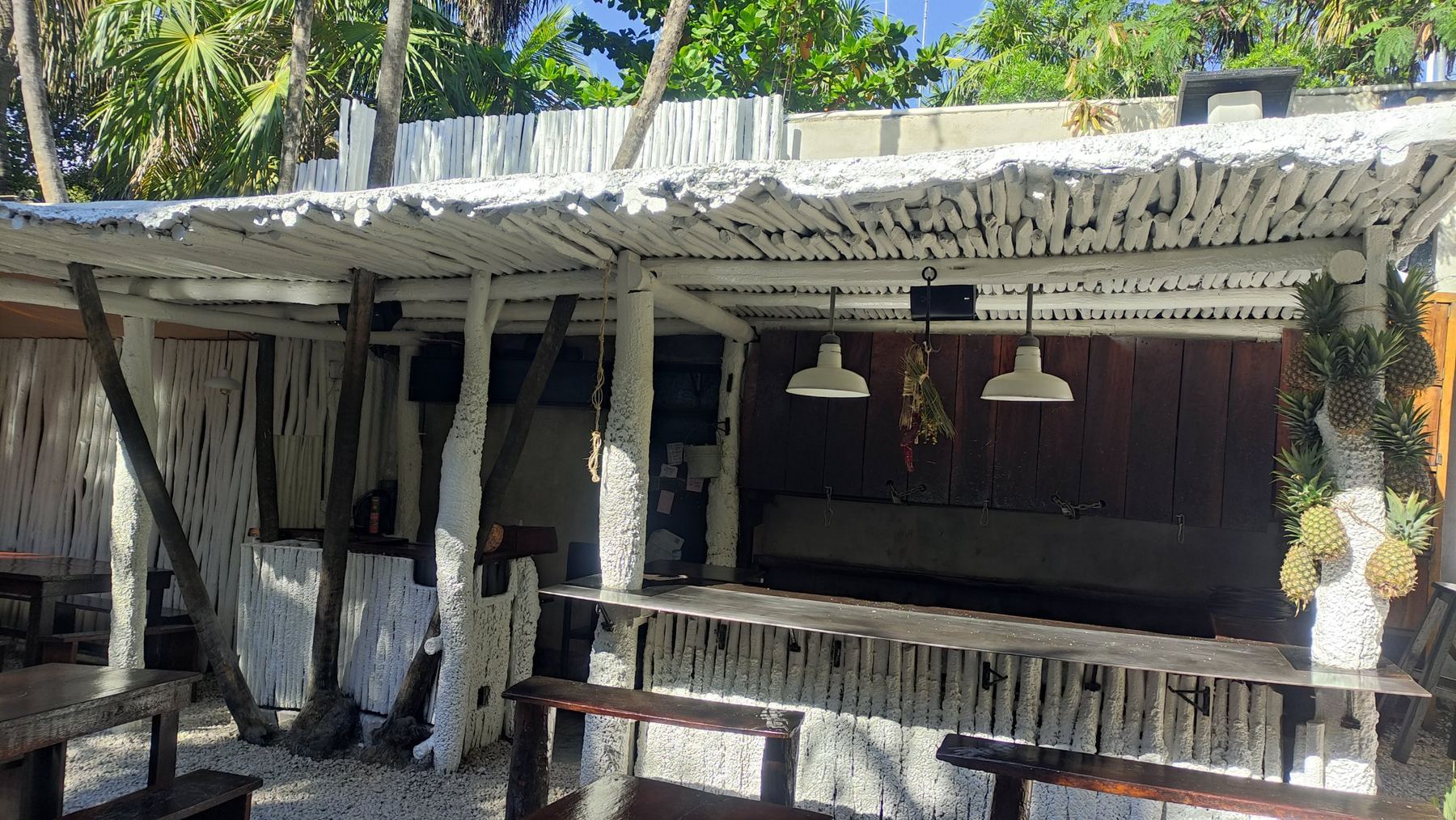Open-air bar with a white timber roof and a loudspeaker above the counter