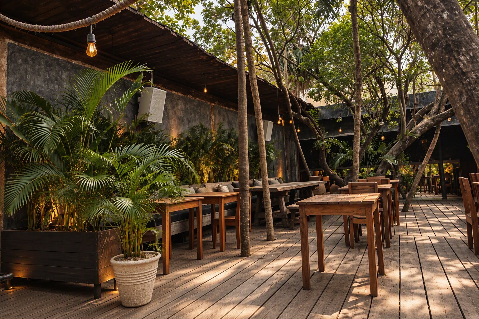 White Martin Audio loudspeakers on the wall of a timber terrace among palms and trees