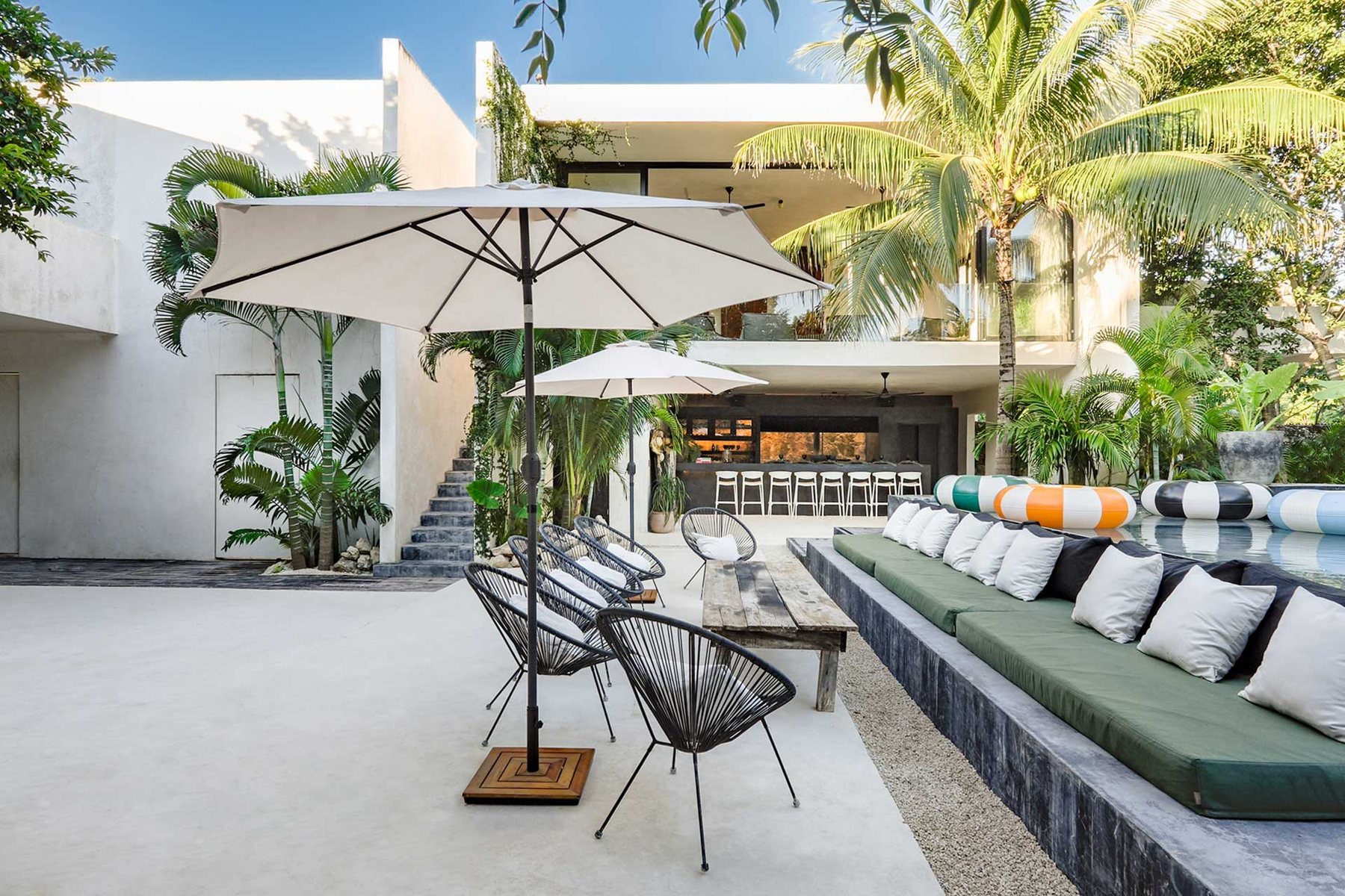 Pool with floats in front of the bar and the house