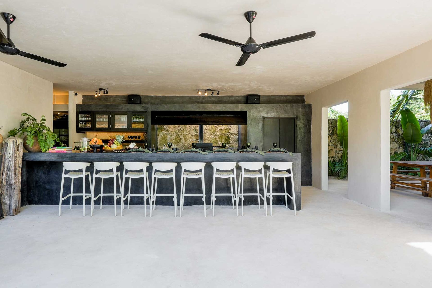 Kitchen bar with white stools and loudspeakers above the wall
