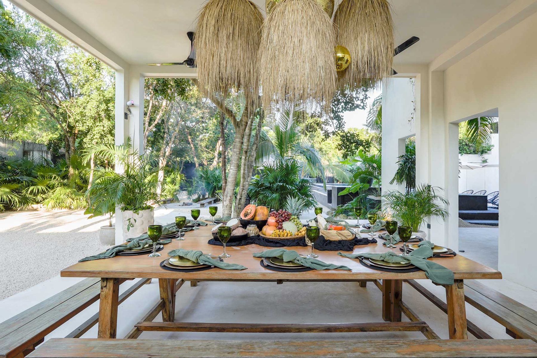 Dining table under palm lamps, open to the garden