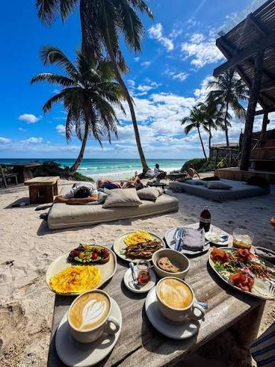 Camastros y desayuno sobre la arena frente al mar