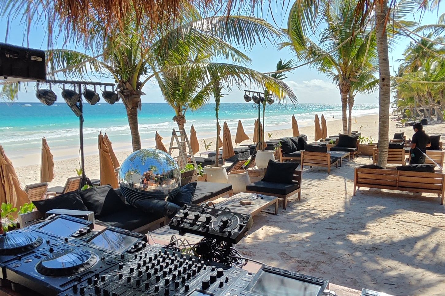 DJ booth under a palapa overlooking the beach