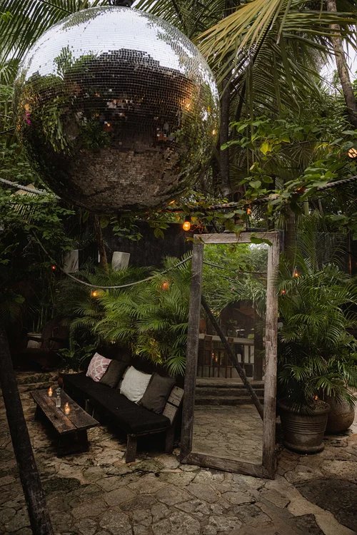 Jungle lounge with a mirror ball and a timber mirror