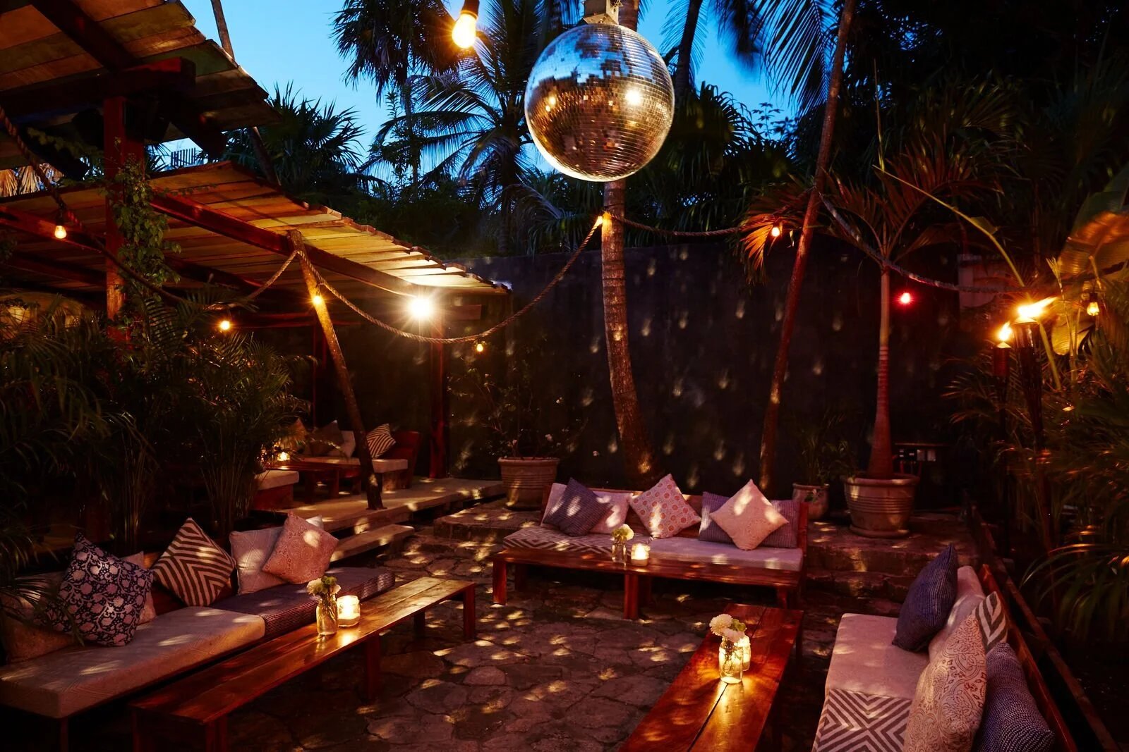 Lounge at night with a mirror ball and torches