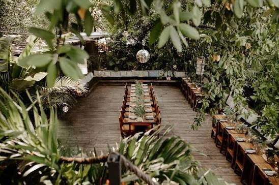Long table set on the timber deck in the jungle