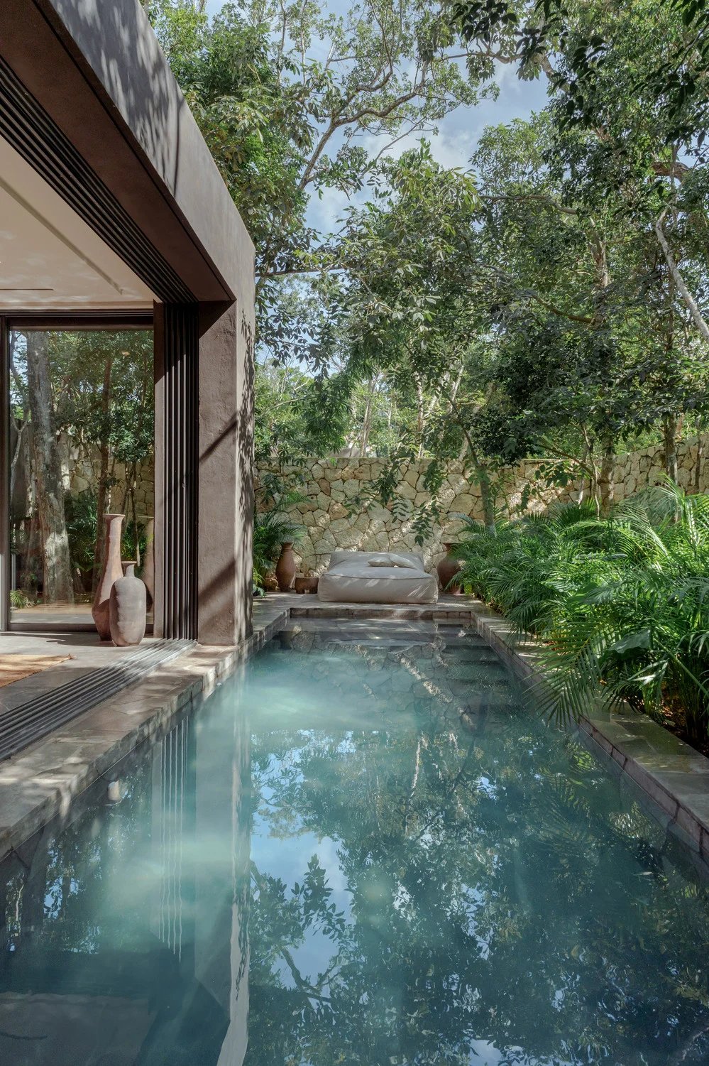Alberca privada junto a la casa, bajo los árboles