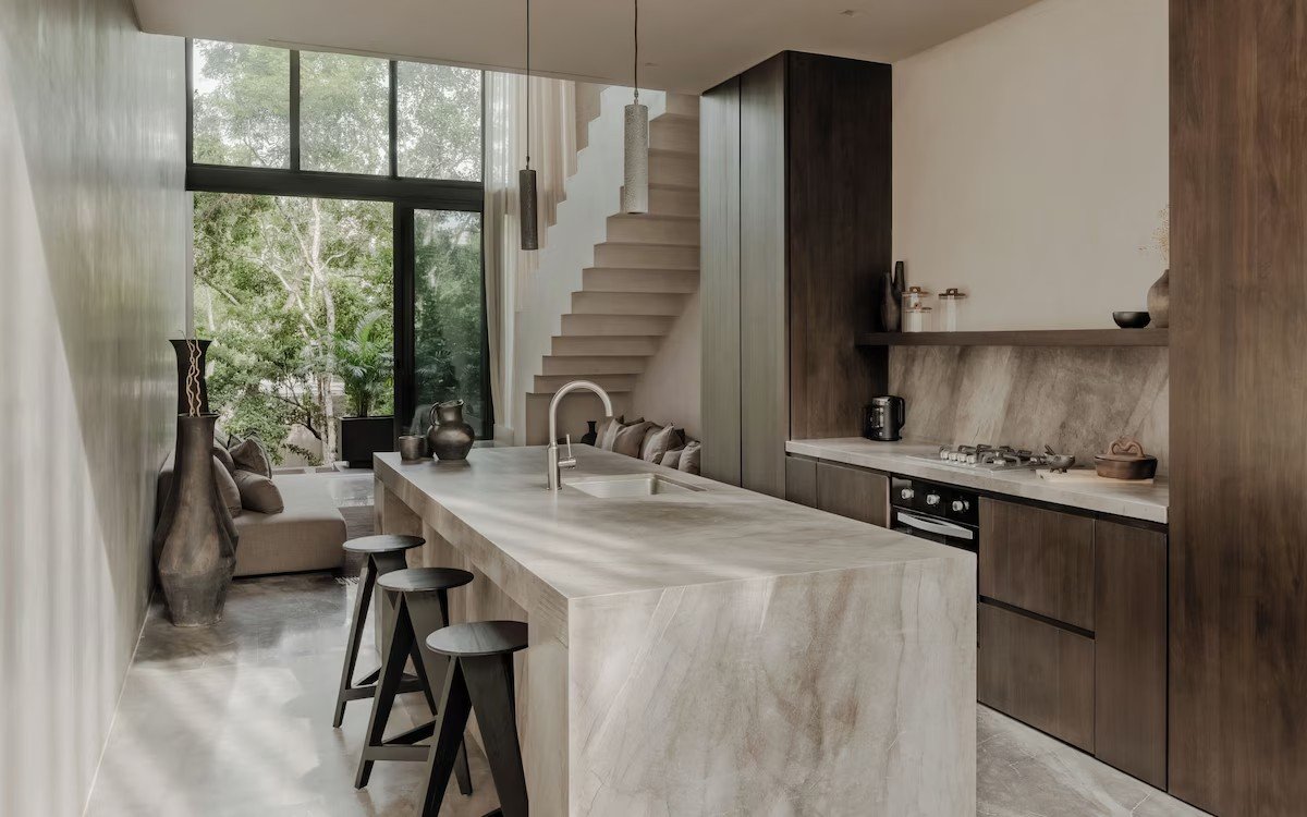 Cocina con isla de mármol y escalera al fondo