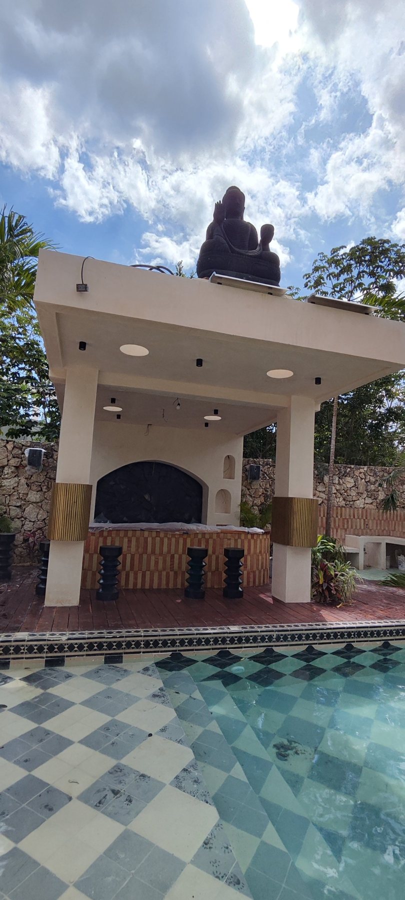 Pergola by the pool with outdoor loudspeakers on the stone walls